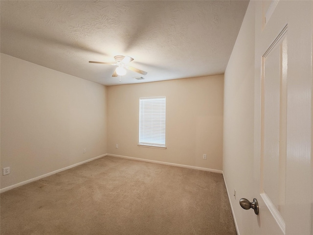 spare room featuring ceiling fan, a textured ceiling, and light carpet