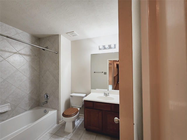 full bathroom with tiled shower / bath combo, tile patterned floors, a textured ceiling, toilet, and vanity