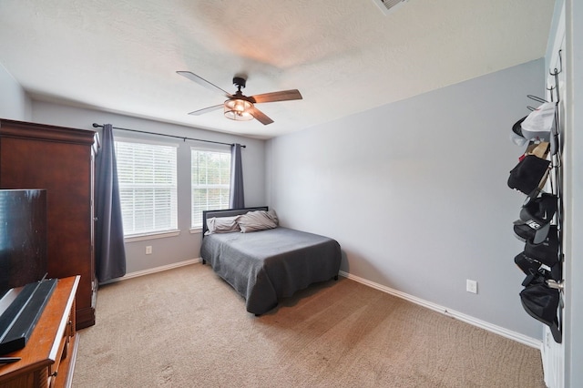 carpeted bedroom with a textured ceiling and ceiling fan