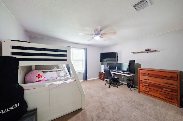 carpeted bedroom featuring ceiling fan and a textured ceiling