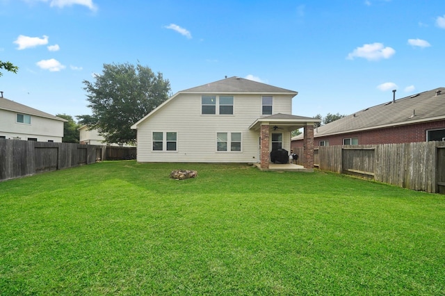 rear view of property with a lawn and a patio