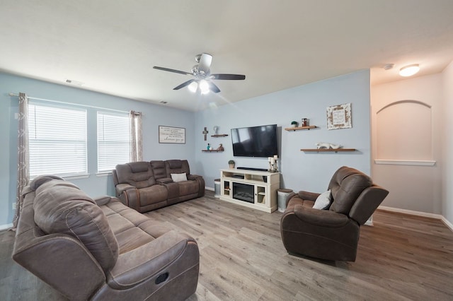 living room with light hardwood / wood-style floors, a fireplace, and ceiling fan