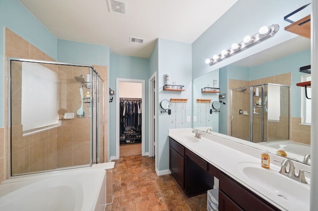 bathroom with vanity and shower with separate bathtub