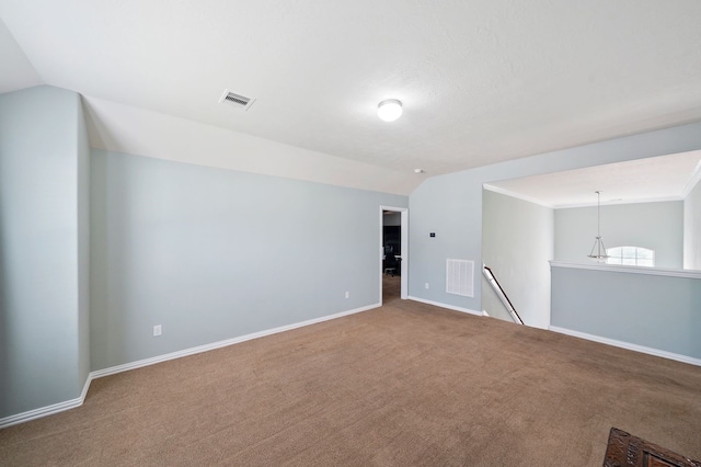 carpeted empty room with vaulted ceiling