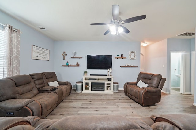 living room featuring ceiling fan, light hardwood / wood-style floors, and a wealth of natural light