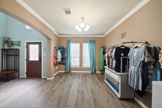 interior space featuring ornamental molding, light hardwood / wood-style flooring, and a notable chandelier