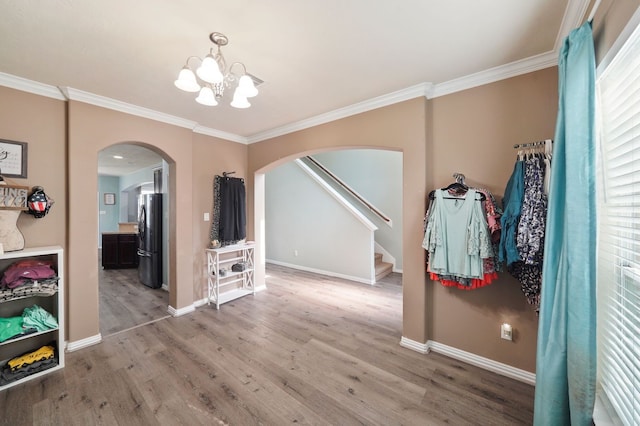 interior space featuring wood-type flooring, a chandelier, and crown molding