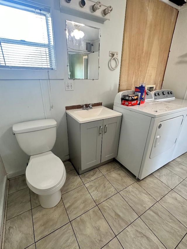 bathroom featuring vanity, washer and clothes dryer, toilet, and tile patterned floors