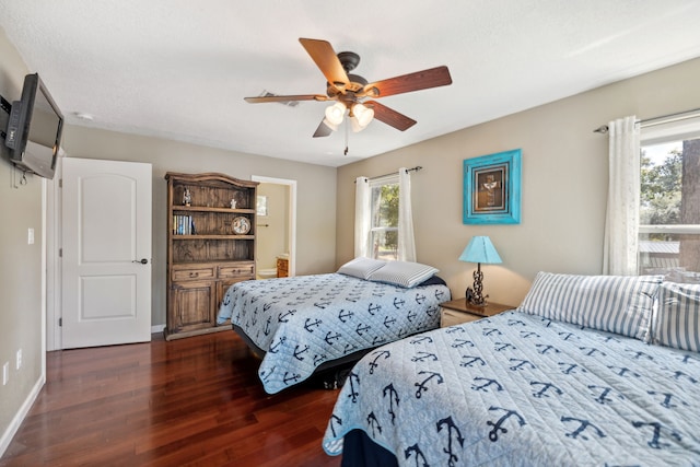 bedroom featuring multiple windows, dark hardwood / wood-style floors, and ceiling fan