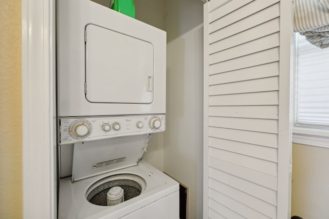 laundry room with stacked washer and dryer and a wealth of natural light