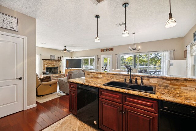 kitchen with wood-type flooring, dishwasher, a fireplace, and sink