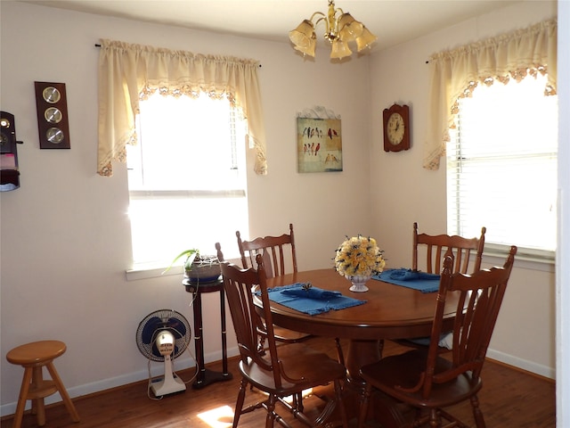 dining room featuring an inviting chandelier, dark wood-type flooring, and plenty of natural light