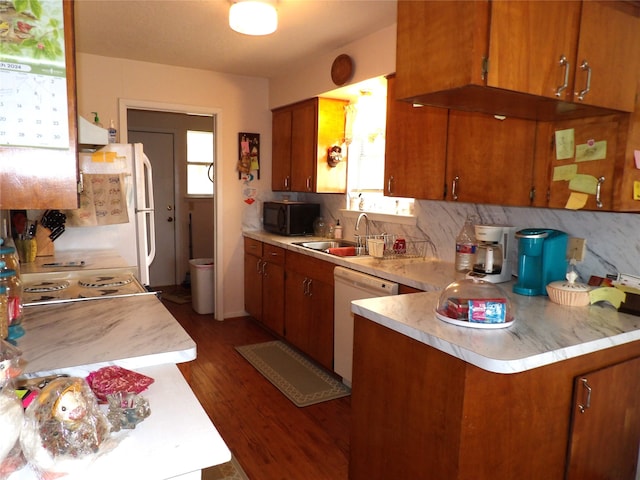 kitchen featuring sink, kitchen peninsula, white appliances, ventilation hood, and dark hardwood / wood-style flooring