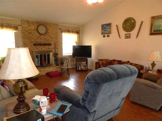 living room featuring a fireplace, lofted ceiling, and hardwood / wood-style flooring