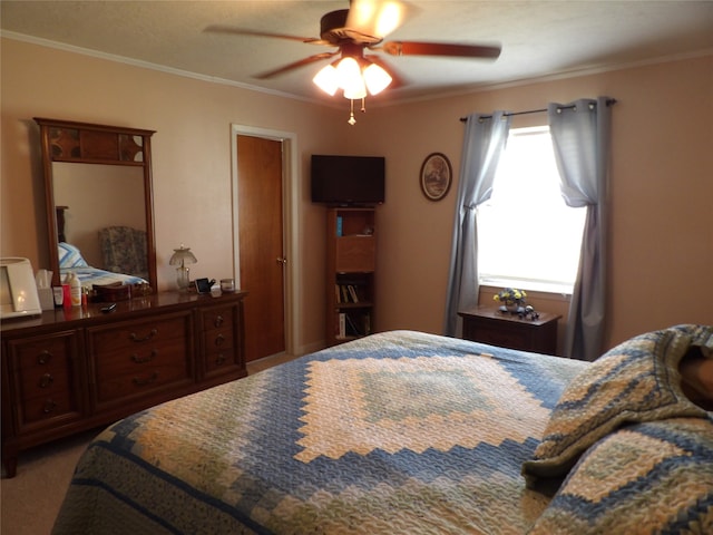 bedroom with ceiling fan, ornamental molding, and carpet