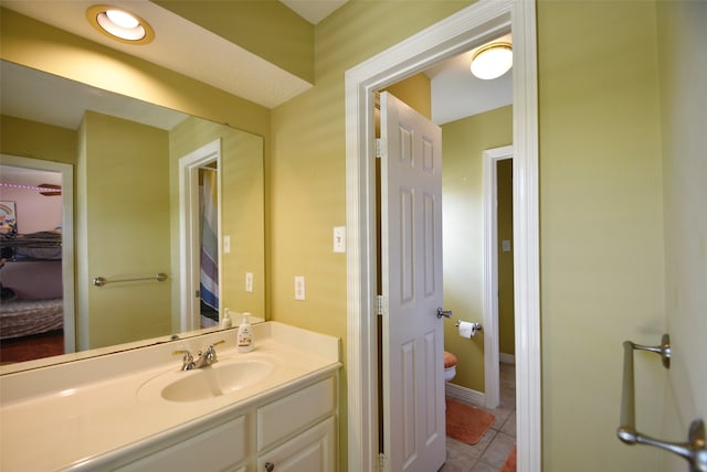 bathroom with tile patterned flooring, vanity, and toilet