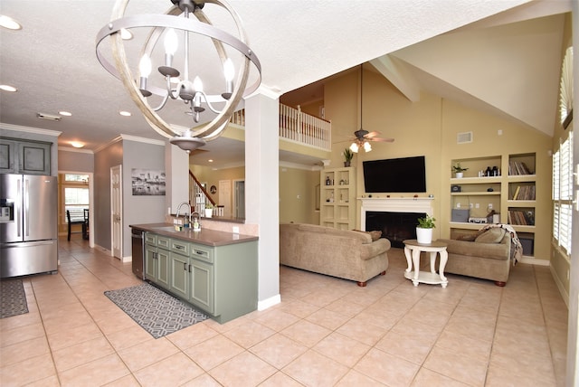 kitchen with appliances with stainless steel finishes, light tile patterned flooring, a textured ceiling, ornamental molding, and sink