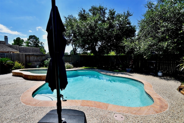 view of swimming pool with an in ground hot tub