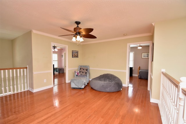 unfurnished room featuring wood-type flooring, a textured ceiling, crown molding, and ceiling fan