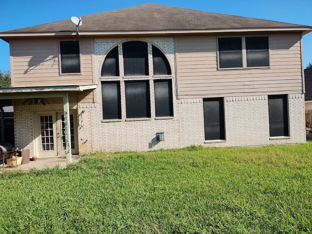 rear view of property featuring a lawn