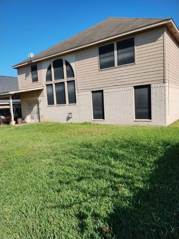 rear view of property featuring a yard