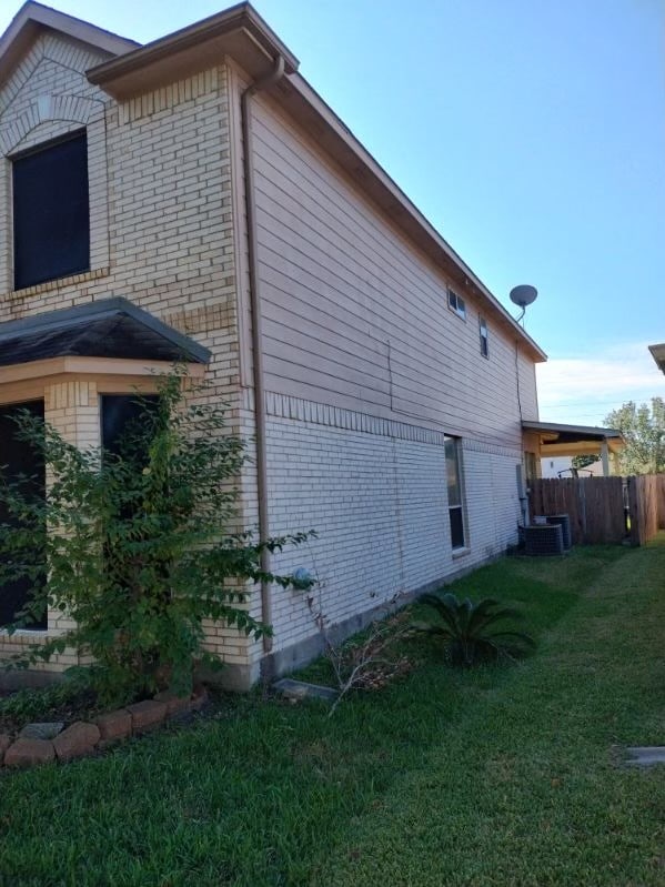 view of property exterior featuring a lawn and central AC unit