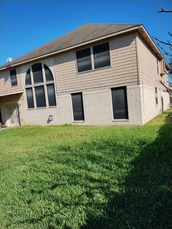 back of property featuring a yard