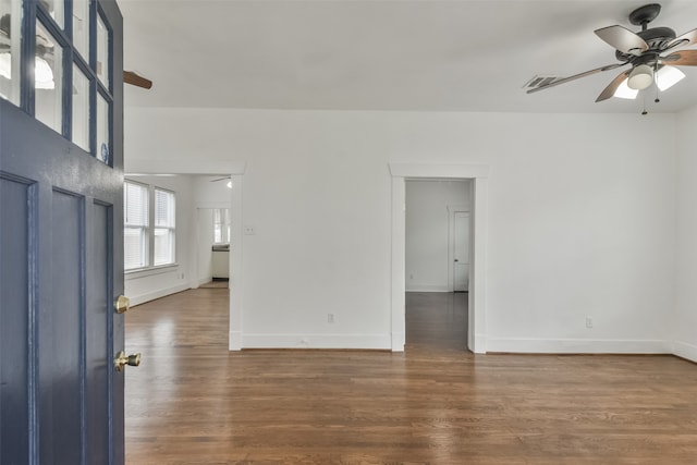 empty room with dark hardwood / wood-style floors and ceiling fan