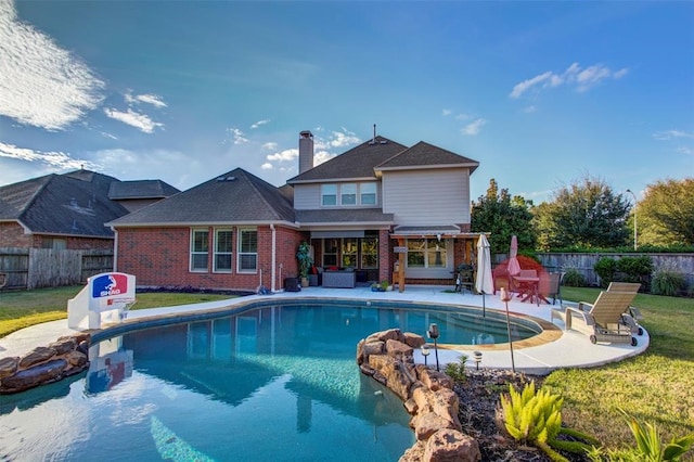 view of pool with a lawn and a patio