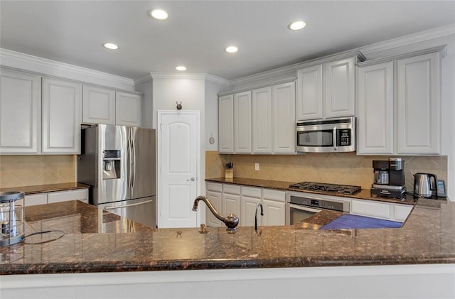 kitchen featuring white cabinets, stainless steel appliances, sink, and dark stone counters