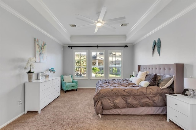 carpeted bedroom with crown molding, a tray ceiling, and ceiling fan