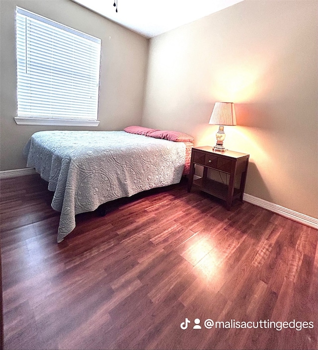 bedroom with dark wood-type flooring