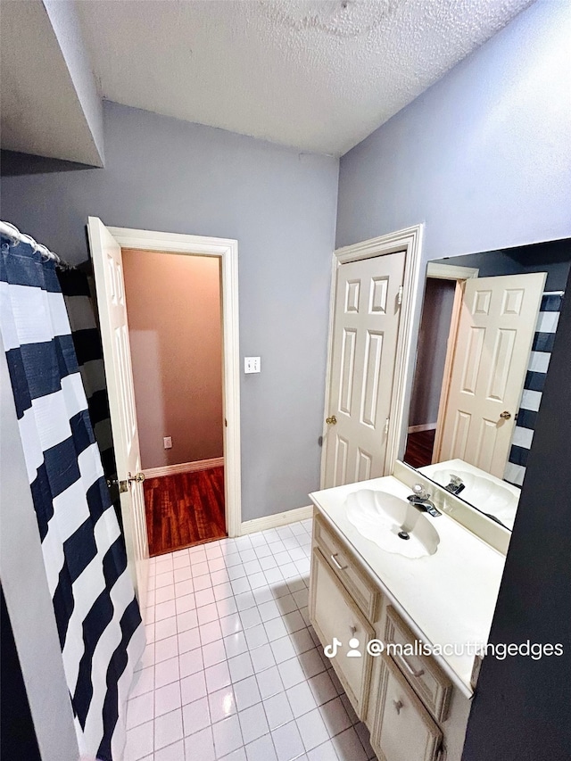 bathroom with vanity, tile patterned flooring, and a textured ceiling