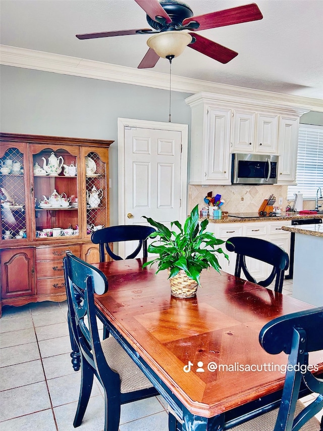 dining space with ceiling fan, light tile patterned flooring, and crown molding