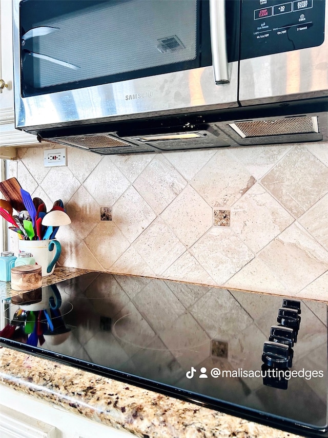 room details featuring black electric cooktop and tasteful backsplash