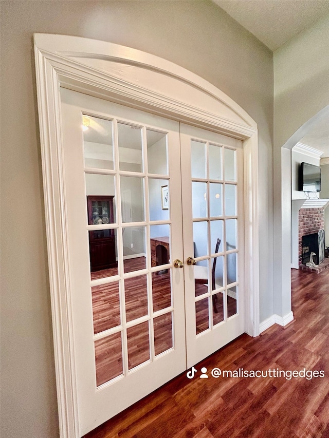 interior details featuring a fireplace, french doors, and hardwood / wood-style floors