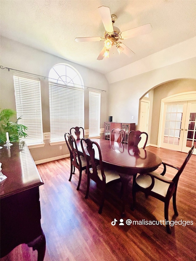 dining area with lofted ceiling, ceiling fan, french doors, wood-type flooring, and a textured ceiling