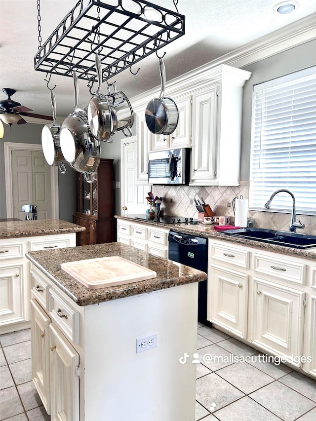 kitchen featuring light tile patterned floors, black dishwasher, sink, and a kitchen island