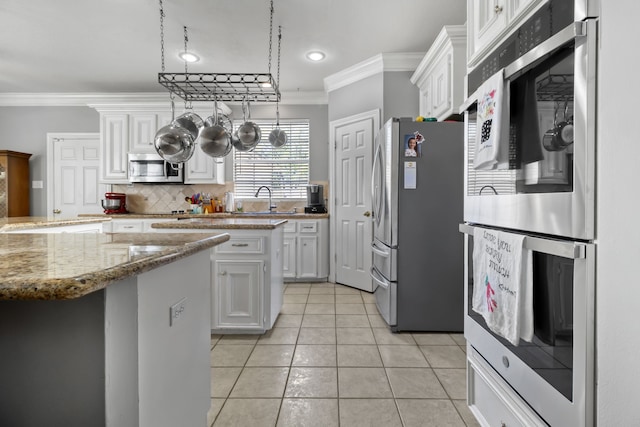 18106 Briden Oak Ct, Spring, TX 77379 - kitchen featuring stainless steel appliances, crown molding, a sink, white cabinetry, and light tile patterned flooring