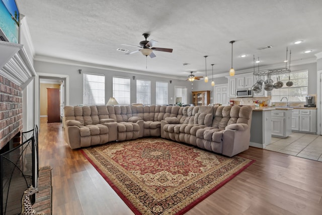 18106 Briden Oak Ct, Spring, TX 77379 - living area featuring ornamental molding, a ceiling fan, light wood-style flooring, a fireplace, and recessed lighting