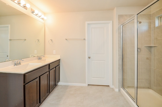 bathroom featuring tile patterned flooring, vanity, and a shower with door