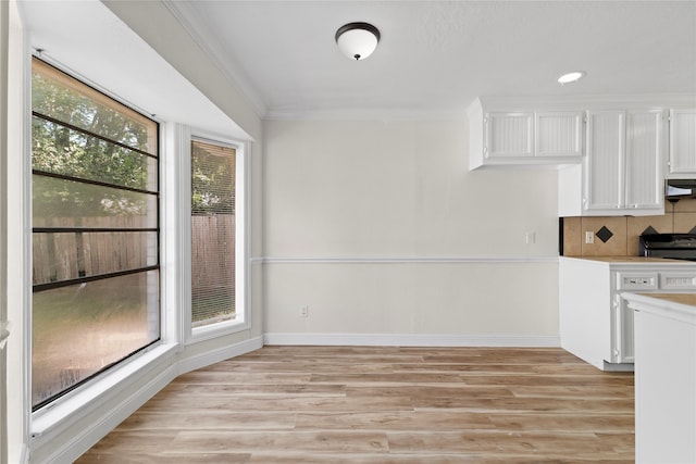 kitchen featuring a healthy amount of sunlight, white cabinetry, light hardwood / wood-style flooring, and tasteful backsplash