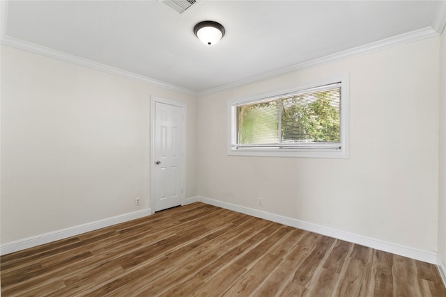 empty room with dark hardwood / wood-style floors and ornamental molding