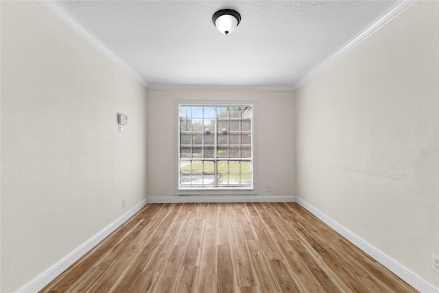 empty room featuring ornamental molding and light hardwood / wood-style floors