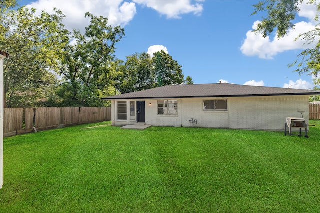 rear view of house with a yard