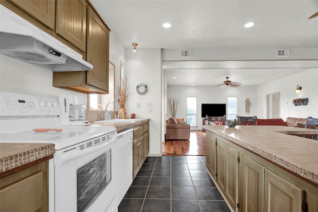 kitchen featuring dark tile patterned flooring, white appliances, ceiling fan, and sink