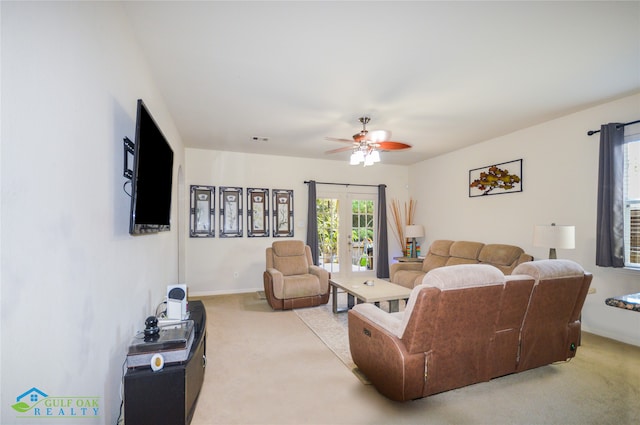 living room featuring light carpet, french doors, and ceiling fan