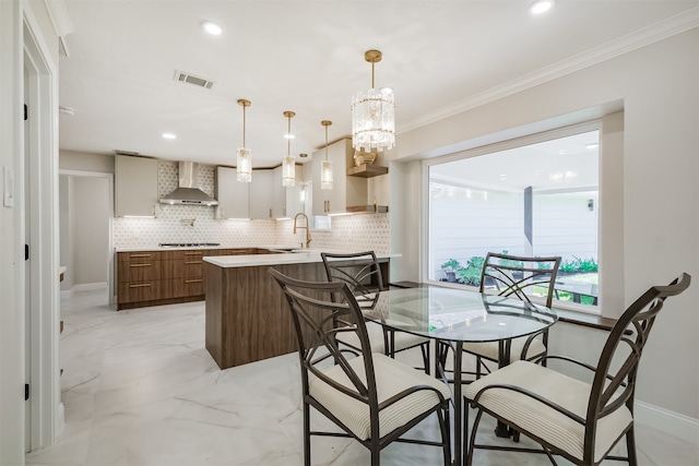 dining space featuring ornamental molding, a chandelier, and sink