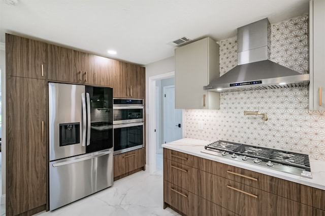 kitchen with appliances with stainless steel finishes, wall chimney exhaust hood, and decorative backsplash