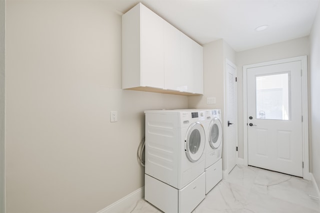 laundry area with washing machine and clothes dryer and cabinets